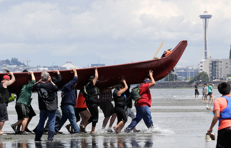 About 20 canoes from Northwest Native coastal tribes landed in July 2019 at Alki Beach on one of several legs of the annual canoe journey that gathers other canoe families from host tribes as they travel to a final landing. (AP Photo / Elaine Thompson, File)