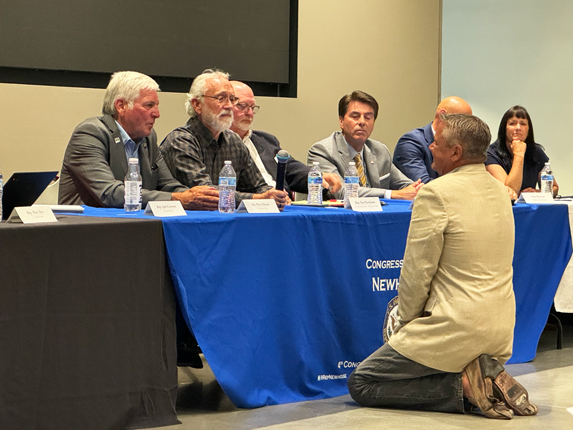 At a Lower Snake River dams forum in the Tri-Cities, Chuck Bender, who said his family members are tugboat operators, fell to his knees in front of U.S. Rep. Dan Newhouse -- pleading to keep the dams, and his family's income source, as it is. (Credit: Courtney Flatt / NWPB)