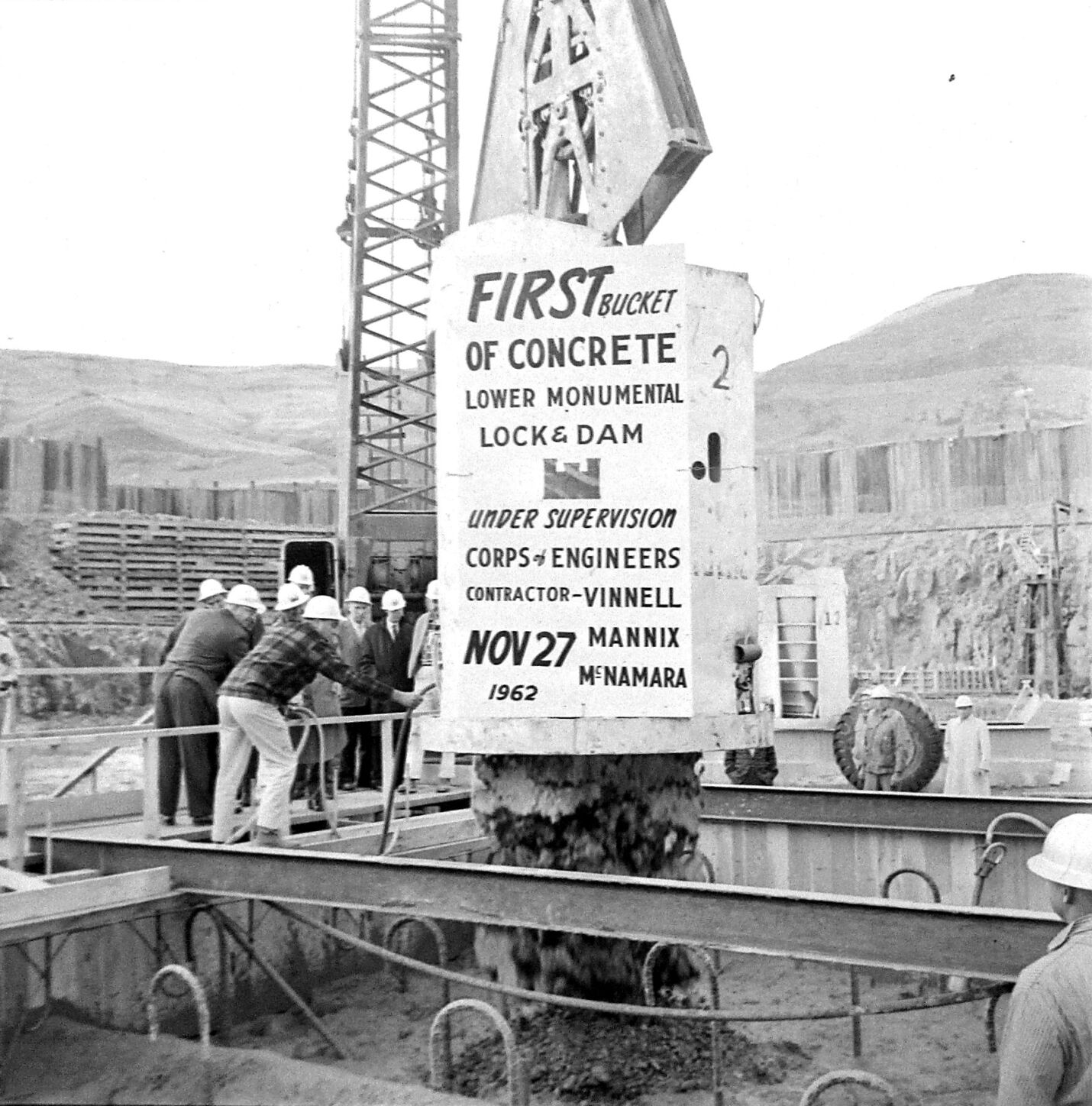 The first concrete poured at Lower Monumental Lock and Dam, Nov. 27, 1962, is commemorated with a sign on the side of the bucket. The hydroelectric run-of-the-river dam on the Snake River bridges Franklin and Walla Walla counties, 43 miles north of Walla Walla and six miles south of Kahlotus.