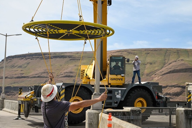 A crane moves a new bubbler to an awaiting boat at Lower Monumental Dam. The bubbler is designed to cool fish ladder water temperatures, which will help migrating fish.