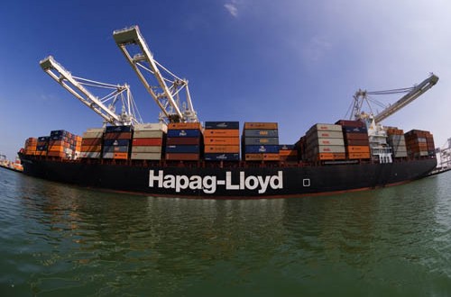 Hapag-Lloyd container ship in the process of being loaded by large container terminal cranes.