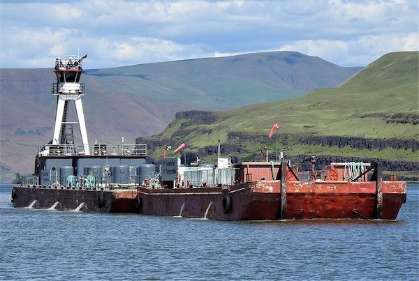 The Tug Umatilla pushes two Corps of Engineers Juvenile Fish Barges into the navigational locks at The Dalles Dam for a trip downstream.