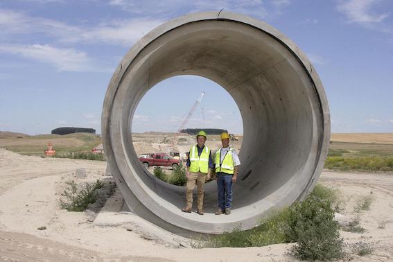 East Columbia Basin Irrigation District engineer Nate Andreini and John McCourtie, assistant manager of operations and maintenance, show the size of the siphons built for the East Low Canal June 26 near Othello, Wash.