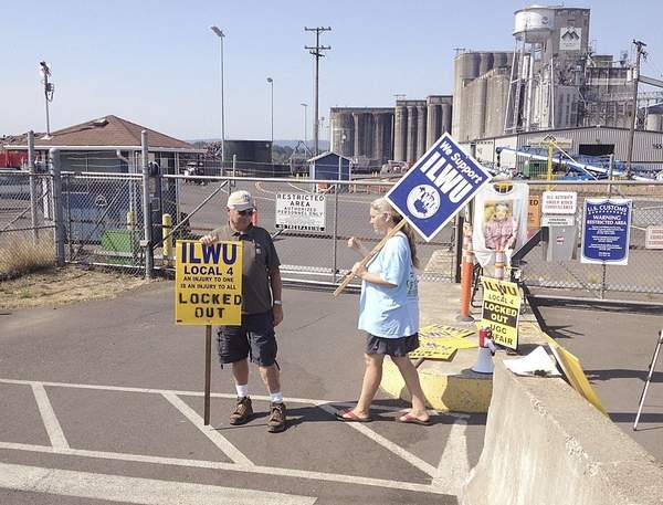Pete Rasmussen and Michelle Bryant picket the United Grain facility in Vancouver, Wash., which locked out workers from the longshoremen's union last year. Longshoremen and several grain exporters have struck a tentative deal in their labor contract negotiations.
