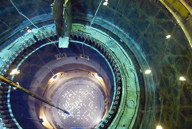 A long robotic arm reaches down through 70-feet of water to move a spent nuclear fuel bundle inside the open core of the reactor at Energy Northwest's Columbia Generating Station during a shutdown for refueling and maintenance.