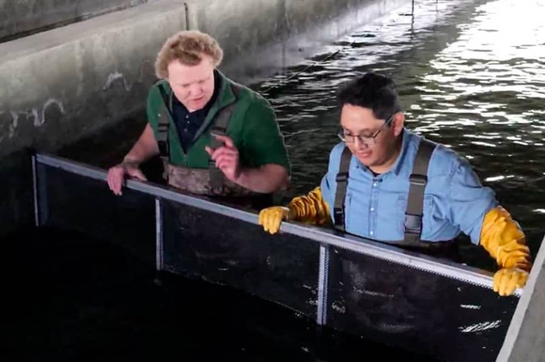 East Idaho News reporter Daniel V. Ramirez in a fish raceway at the Springfield Fish Hatchery with it's Manager Ross Stadt. (Jordan Wood photo)