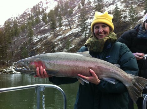 A fisherwoman proudly displays her steelhead catch.