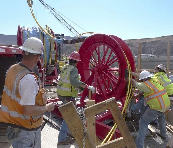 Workers start the installation of the first of 37 large steel tendons up to 150 feet long inside Wanapum Dam on Sept. 3. The tendons will be anchored in bedrock below the dam and strengthen it following a Feb. 27 crack.