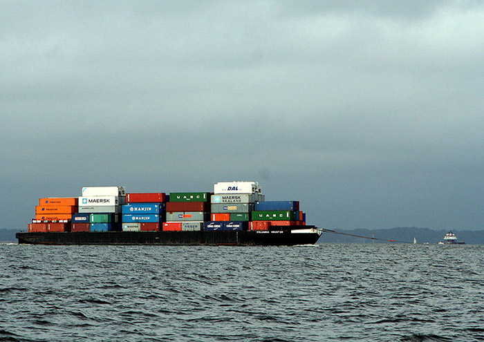 A barge loaded with containers awaiting transfer to ocean-going vessel and shipment to Asia.