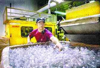 Employee Keith Marcott sorts through a bin containing 24,000 plastic bottle manufactured by injection machines Monday at CNC Container Corp. in the Mottman Industrial Park. The company is battling energy costs by shutting down eight of the machines and bringing in generators to power the plant.