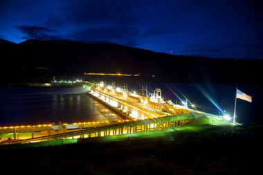 (Jamie Francis) The John Day Dam, like others on the Columbia and Snake rivers, has moved to 24-hour spill -- that's the white water in the background -- to keep young fish out of its churning hydropower turbines. Debate is ongoing over whether to spill 30 percent or 40 percent of the river's volume instead of generating power, and over drawing down the 76-mile reservoir that backs up behind the dam to help speed downstream migration of juvenile salmon and steelhead.