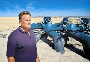 (Dave Wilkins) Randy Brown of the South West Irrigation District stands near a booster station, part of the new West Cassia Pipeline project. The pipeline includes three 24-inch-diameter trunk lines.