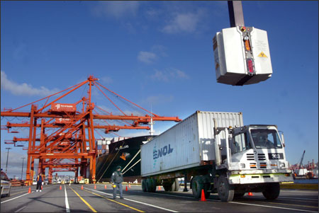 (Karen Ducey) A truck carrying a container just loaded off a ship at the Port of Seattle passes under a giant X-ray machine called VACAS, which looks for suspicious cargo and is operated by the Customs and Border Protection agency.