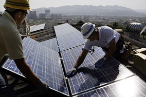 (The Daily Reporter) Solar panels being installed on rooftops.