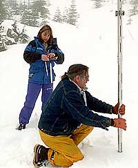 (Steve Ringman) Inspectors record the depth and weight of snow at a Cascades sample site.