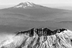 The western flank of Mount St. Helens is dark after Friday's 24-minute eruption of steam and ash. Mount Adams is in the background. -- Right: A photograph taken Monday from the same angle shows streaks of snow on the west side of the mountain. It is unclear whether Friday's activity melted the snow or covered it with ash. 